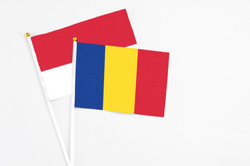 Romania and Monaco stick flags on white background. High quality fabric, miniature national flag. Peaceful global concept.White floor for copy space.
