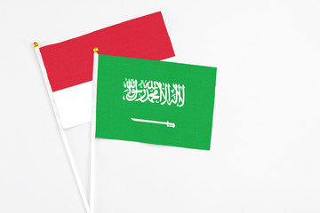 Saudi Arabia and Monaco stick flags on white background. High quality fabric, miniature national flag. Peaceful global concept.White floor for copy space.