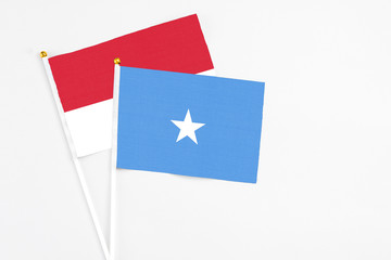 Somalia and Monaco stick flags on white background. High quality fabric, miniature national flag. Peaceful global concept.White floor for copy space.