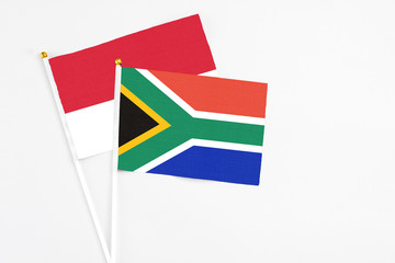 South Africa and Monaco stick flags on white background. High quality fabric, miniature national flag. Peaceful global concept.White floor for copy space.