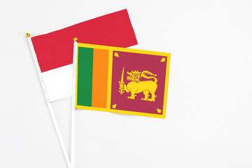 Sri Lanka and Monaco stick flags on white background. High quality fabric, miniature national flag. Peaceful global concept.White floor for copy space.