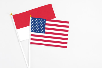 United States and Monaco stick flags on white background. High quality fabric, miniature national flag. Peaceful global concept.White floor for copy space.