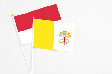 Vatican City and Monaco stick flags on white background. High quality fabric, miniature national flag. Peaceful global concept.White floor for copy space.
