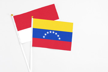 Venezuela and Monaco stick flags on white background. High quality fabric, miniature national flag. Peaceful global concept.White floor for copy space.