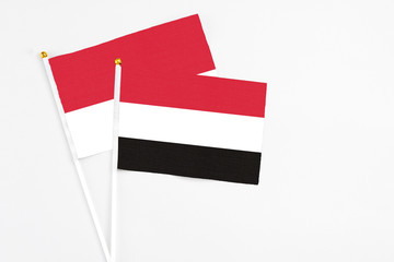 Yemen and Monaco stick flags on white background. High quality fabric, miniature national flag. Peaceful global concept.White floor for copy space.