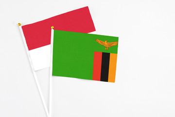 Zambia and Monaco stick flags on white background. High quality fabric, miniature national flag. Peaceful global concept.White floor for copy space.