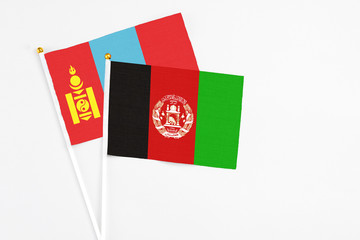 Afghanistan and Mongolia stick flags on white background. High quality fabric, miniature national flag. Peaceful global concept.White floor for copy space.