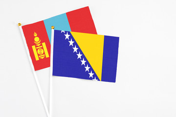 Bosnia Herzegovina and Mongolia stick flags on white background. High quality fabric, miniature national flag. Peaceful global concept.White floor for copy space.