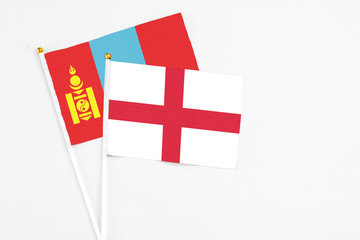 England and Mongolia stick flags on white background. High quality fabric, miniature national flag. Peaceful global concept.White floor for copy space.