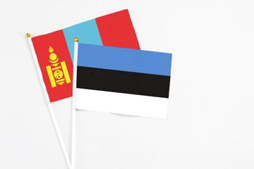 Estonia and Mongolia stick flags on white background. High quality fabric, miniature national flag. Peaceful global concept.White floor for copy space.