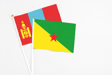 French Guiana and Mongolia stick flags on white background. High quality fabric, miniature national flag. Peaceful global concept.White floor for copy space.