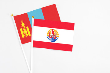 French Polynesia and Mongolia stick flags on white background. High quality fabric, miniature national flag. Peaceful global concept.White floor for copy space.