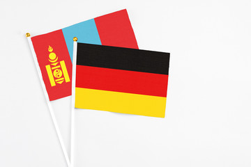 Germany and Mongolia stick flags on white background. High quality fabric, miniature national flag. Peaceful global concept.White floor for copy space.