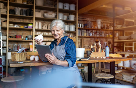 Senior craftswoman with tablet computer in art studio