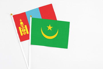 Mauritania and Mongolia stick flags on white background. High quality fabric, miniature national flag. Peaceful global concept.White floor for copy space.