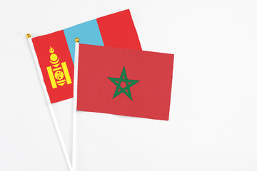 Morocco and Mongolia stick flags on white background. High quality fabric, miniature national flag. Peaceful global concept.White floor for copy space.