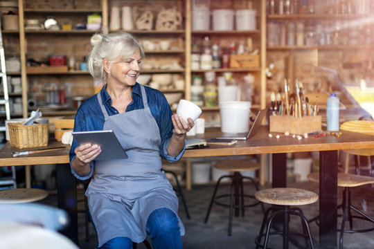 Senior craftswoman with tablet computer in art studio