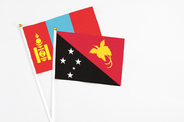 Papua New Guinea and Mongolia stick flags on white background. High quality fabric, miniature national flag. Peaceful global concept.White floor for copy space.