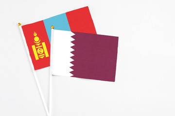 Qatar and Mongolia stick flags on white background. High quality fabric, miniature national flag. Peaceful global concept.White floor for copy space.