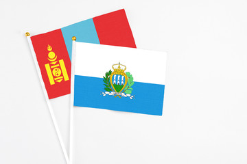 San Marino and Mongolia stick flags on white background. High quality fabric, miniature national flag. Peaceful global concept.White floor for copy space.