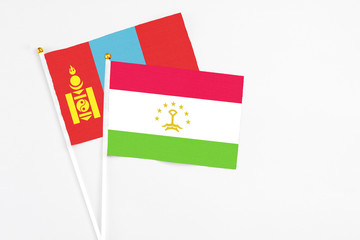 Tajikistan and Mongolia stick flags on white background. High quality fabric, miniature national flag. Peaceful global concept.White floor for copy space.