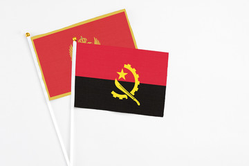 Angola and Montenegro stick flags on white background. High quality fabric, miniature national flag. Peaceful global concept.White floor for copy space.