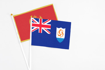 Fototapeta premium Anguilla and Montenegro stick flags on white background. High quality fabric, miniature national flag. Peaceful global concept.White floor for copy space.
