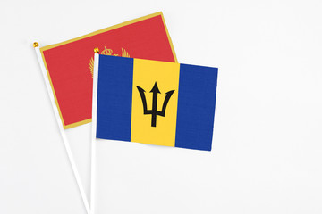 Barbados and Montenegro stick flags on white background. High quality fabric, miniature national flag. Peaceful global concept.White floor for copy space.
