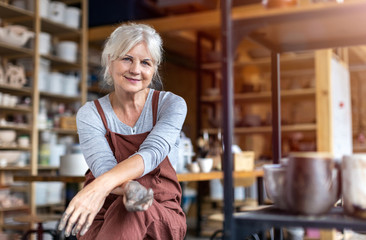 Portrait of senior female pottery artist in her art studio