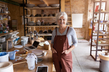 Portrait of senior female pottery artist in her art studio