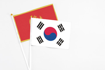 South Korea and Montenegro stick flags on white background. High quality fabric, miniature national flag. Peaceful global concept.White floor for copy space.