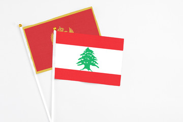 Lebanon and Montenegro stick flags on white background. High quality fabric, miniature national flag. Peaceful global concept.White floor for copy space.