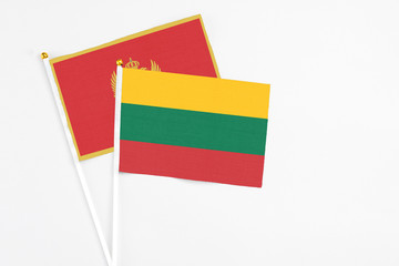 Lithuania and Montenegro stick flags on white background. High quality fabric, miniature national flag. Peaceful global concept.White floor for copy space.