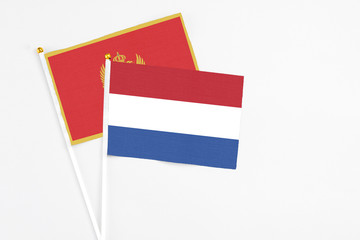 Netherlands and Montenegro stick flags on white background. High quality fabric, miniature national flag. Peaceful global concept.White floor for copy space.