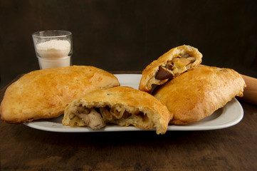 Homemade pies on a white plate with shiitake mushrooms and a glass with flour