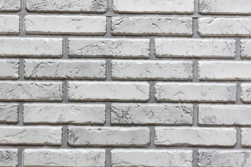 Weathered texture of light gray brick wall background in rural room, grungy rusty blocks of stonework technology.