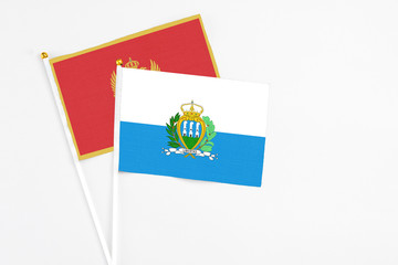 San Marino and Montenegro stick flags on white background. High quality fabric, miniature national flag. Peaceful global concept.White floor for copy space.