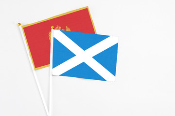 Scotland and Montenegro stick flags on white background. High quality fabric, miniature national flag. Peaceful global concept.White floor for copy space.