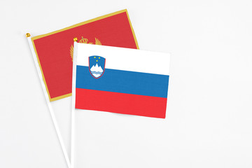 Slovenia and Montenegro stick flags on white background. High quality fabric, miniature national flag. Peaceful global concept.White floor for copy space.