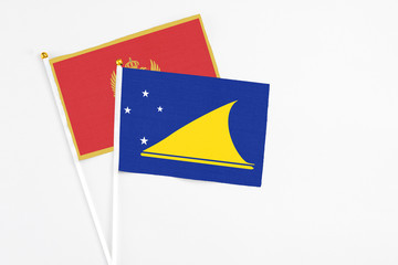 Tokelau and Montenegro stick flags on white background. High quality fabric, miniature national flag. Peaceful global concept.White floor for copy space.