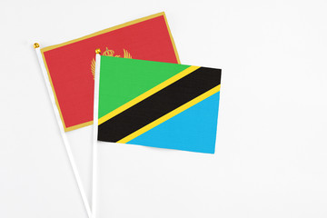 Tanzania and Montenegro stick flags on white background. High quality fabric, miniature national flag. Peaceful global concept.White floor for copy space.