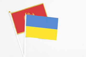 Ukraine and Montenegro stick flags on white background. High quality fabric, miniature national flag. Peaceful global concept.White floor for copy space.