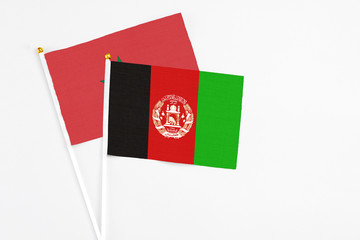 Afghanistan and Morocco stick flags on white background. High quality fabric, miniature national flag. Peaceful global concept.White floor for copy space.
