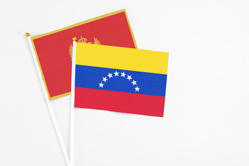 Venezuela and Montenegro stick flags on white background. High quality fabric, miniature national flag. Peaceful global concept.White floor for copy space.