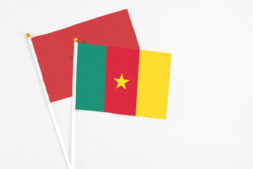 Cameroon and Morocco stick flags on white background. High quality fabric, miniature national flag. Peaceful global concept.White floor for copy space.