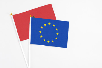 European Union and Morocco stick flags on white background. High quality fabric, miniature national flag. Peaceful global concept.White floor for copy space.