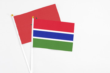 Gambia and Morocco stick flags on white background. High quality fabric, miniature national flag. Peaceful global concept.White floor for copy space.