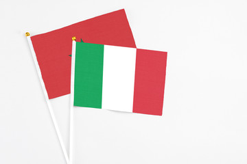 Italy and Morocco stick flags on white background. High quality fabric, miniature national flag. Peaceful global concept.White floor for copy space.