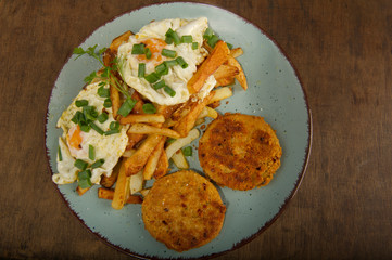 Two hamburgers with french fries, eggs and onions