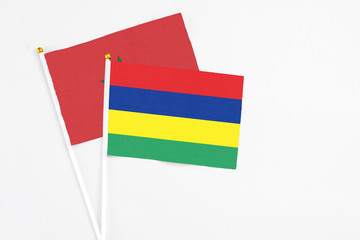 Mauritius and Morocco stick flags on white background. High quality fabric, miniature national flag. Peaceful global concept.White floor for copy space.